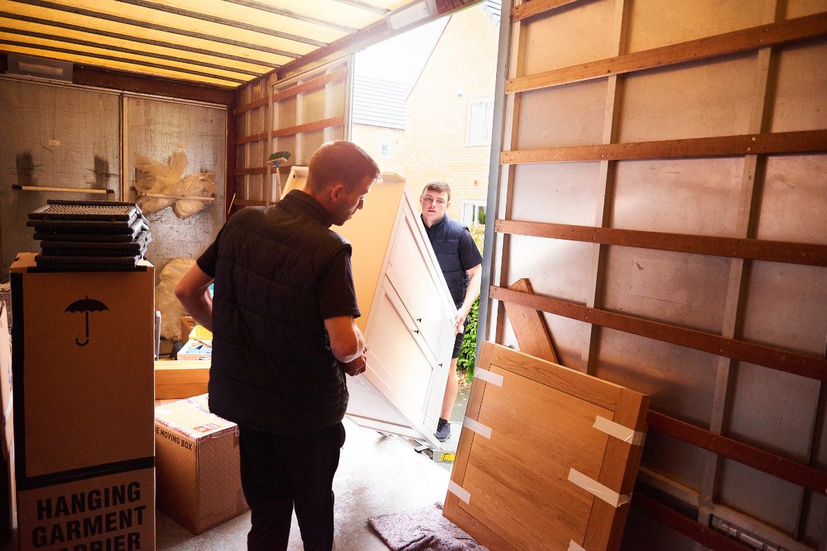 Two men are moving boxes into a truck, representing a specialized junk removal service in Fresno, CA.